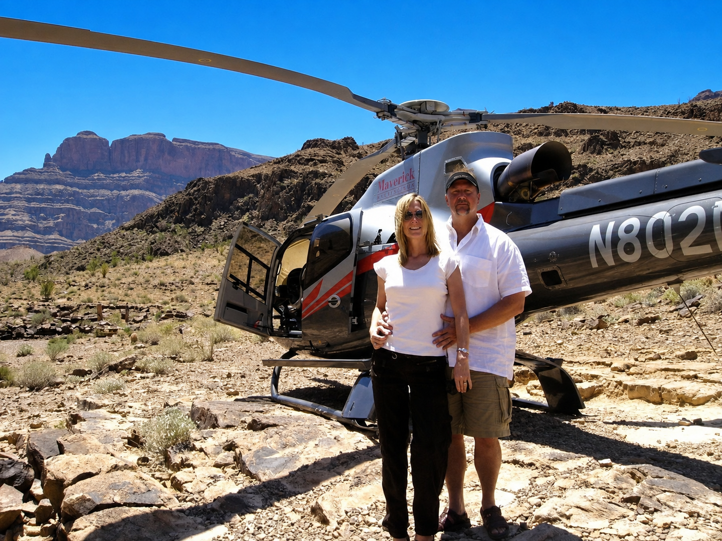Mark and Jill beside a helicopter in a canyon