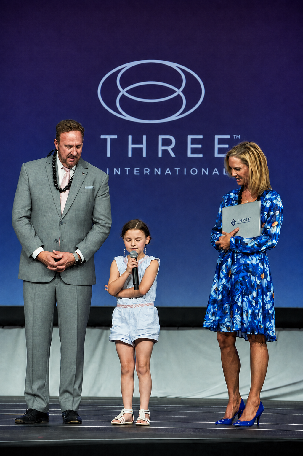 Mark, Jill, and family sharing a quiet moment on stage