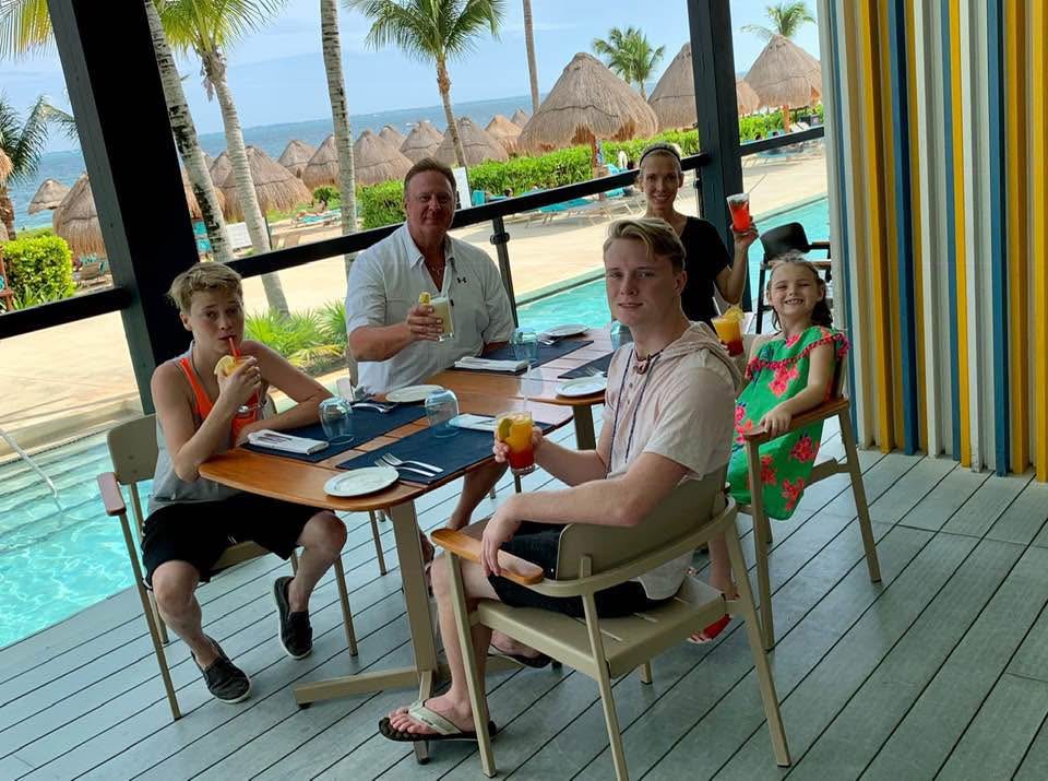 Family sharing a meal beside a pool