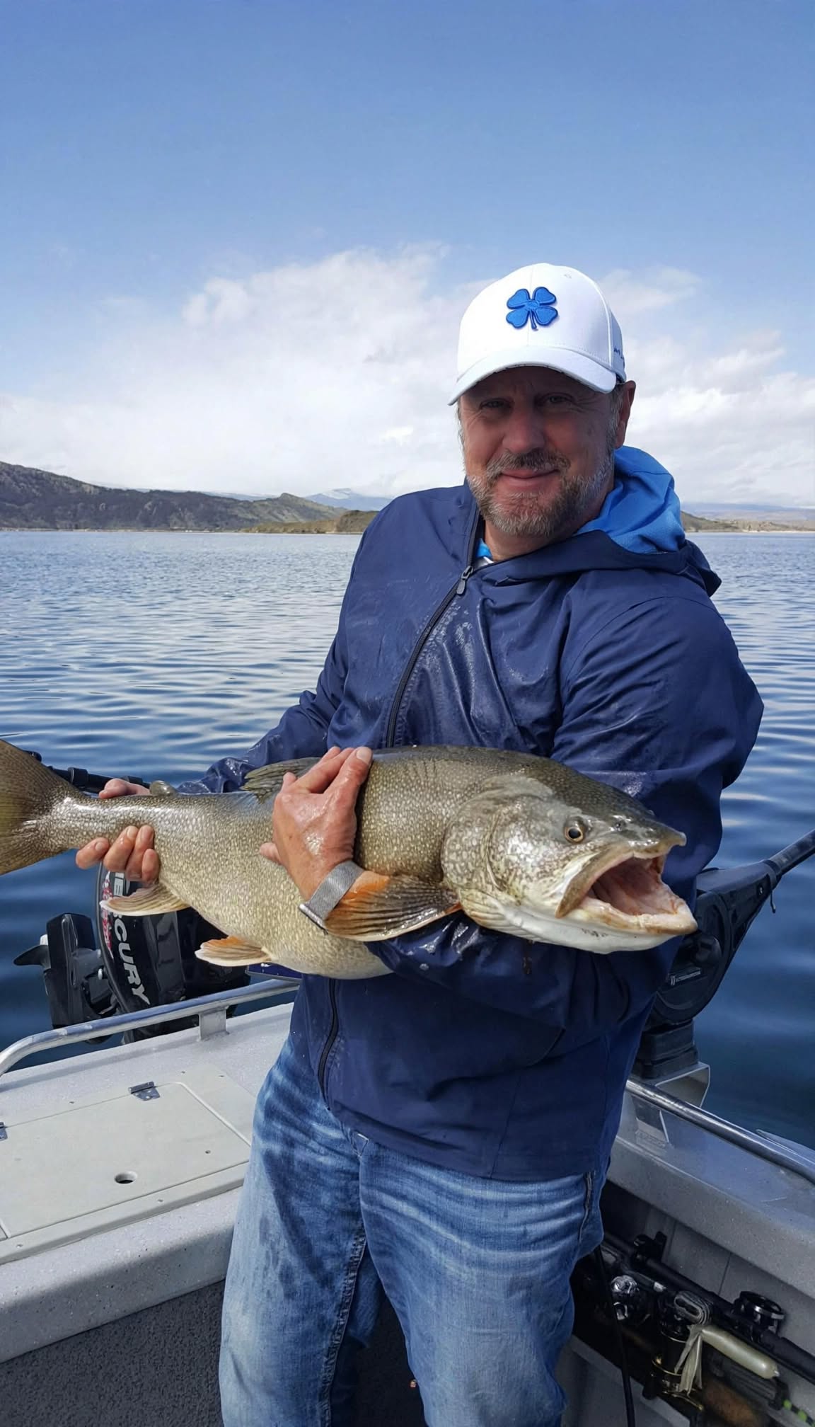 Mark holding a lake trout while fishing