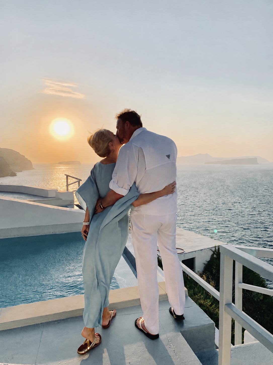 Mark and Jill sharing a kiss at sunset beside the sea